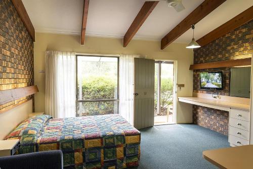 a bedroom with a bed and a large window at Pinnacle Holiday Lodge in Halls Gap
