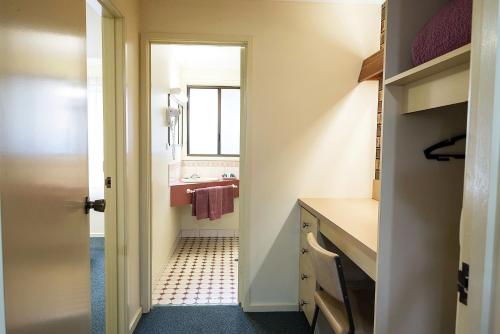 a small bathroom with a sink and a mirror at Pinnacle Holiday Lodge in Halls Gap