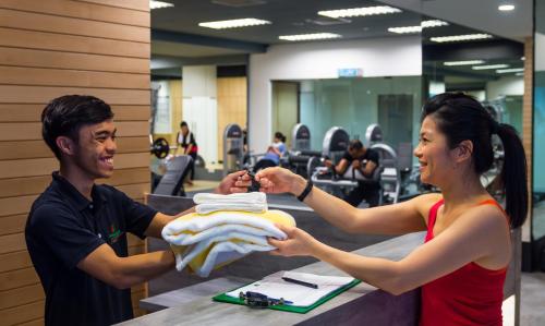 a man and a woman holding a pile of towels at Imperial Hotel Kuching in Kuching