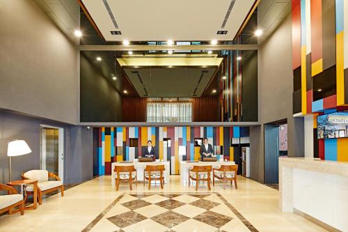 a lobby with colorful walls and a table and chairs at Hotel Sukimi in Tainan