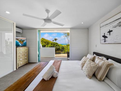 una camera da letto con un letto e un ventilatore a soffitto di Cotton Tree Beach Front 3 Bedroom Townhouse a Maroochydore