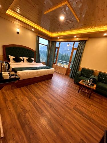 a large bedroom with a bed and a large window at Hidden Heaven Old Manali by velvet loft in Manāli