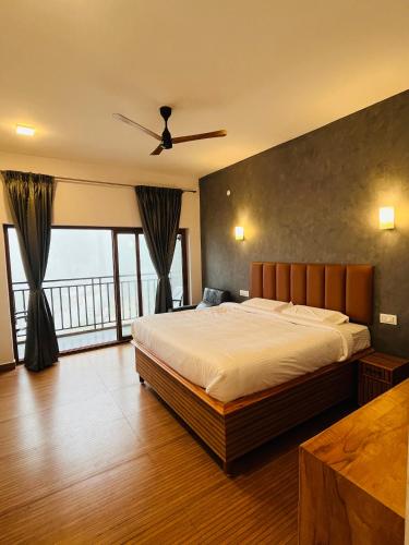 Un dormitorio con una cama grande con ventilador de techo. en Leaves, en Yercaud