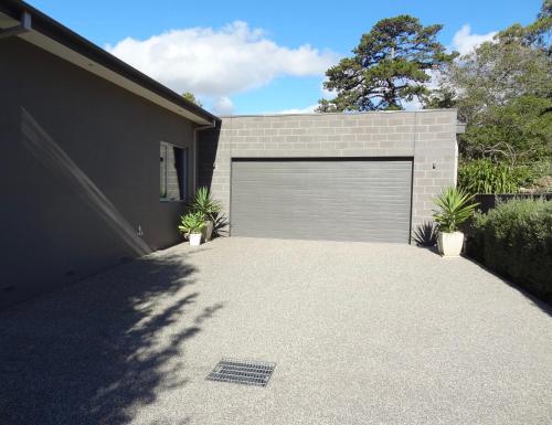 a garage door with two plants in front of a house at The Gallery Accommodation McCrae in McCrae
