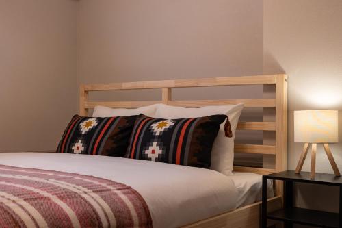 a bedroom with a wooden bed with pillows and a lamp at Villa Gotemba Fuji in Gotemba