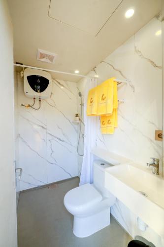 a white bathroom with a toilet and a sink at Meadows Villa in Uluwatu