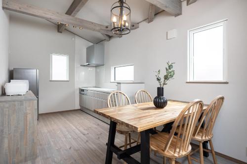 a kitchen and dining room with a wooden table and chairs at Villa Gotemba Fuji in Gotemba