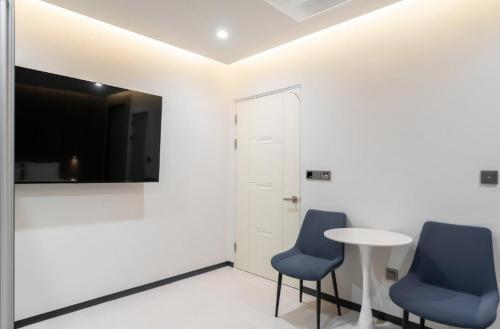 two blue chairs and a table in a room at Cheomdan Lantana Hotel in Gwangju