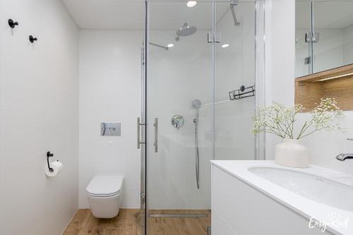 a bathroom with a shower and a toilet and a sink at Prestige Pinea 613 - basen, sauna, jacuzzi w cenie pobytu - Easy - Rent Apartments in Pobierowo