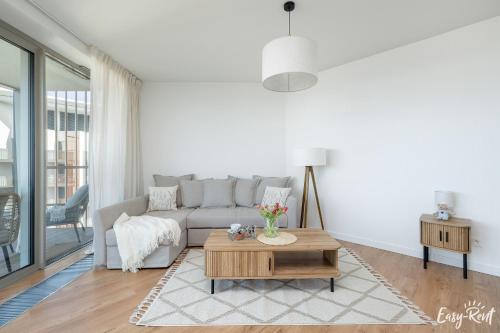 a living room with a couch and a coffee table at Prestige Pinea 613 - basen, sauna, jacuzzi w cenie pobytu - Easy - Rent Apartments in Pobierowo