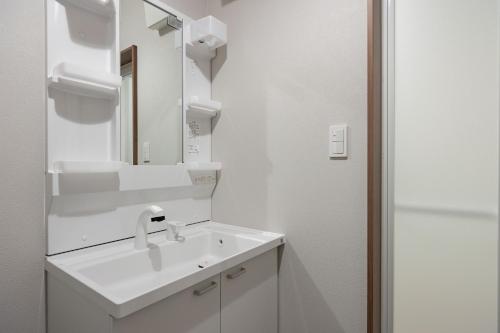 a white bathroom with a sink and a mirror at Villa Gotemba Fuji in Gotemba