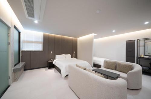 a large bedroom with a bed and a couch at Cheomdan Lantana Hotel in Gwangju