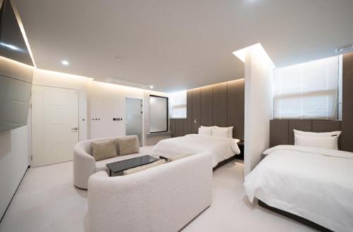 a hotel room with two beds and a couch at Cheomdan Lantana Hotel in Gwangju