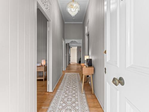 a hallway with a door and a rug at Silkstone Cottage in Bundamba