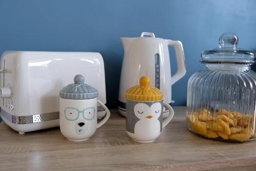 3 tasses de chaton assises sur un comptoir à côté d'un grille-pain dans l'établissement Collioure, appartement clair, terrasse et parking, à Collioure