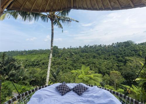 TampaksiringにあるThe Scape Valley Villas by GenuineHostのヤシの木があるリゾート内のベッド1台