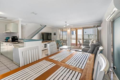 a kitchen and living room with a table and chairs at McNaughton Townhouse in Redcliffe