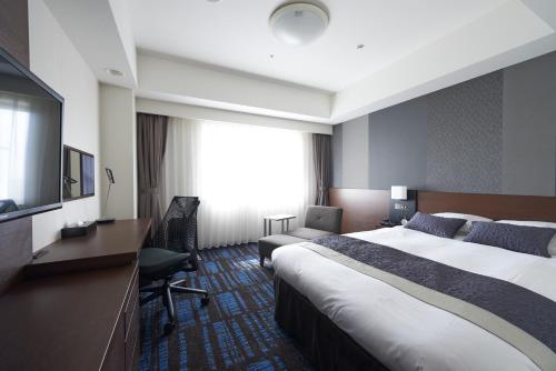 a hotel room with a large bed and a television at HOTEL VISCHIO AMAGASAKI by GRANVIA in Amagasaki