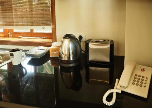 a coffee maker and a phone in a room at The Gecho Inn Country in Jepara