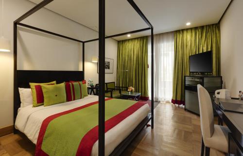 a bedroom with a large bed and a television at The Park Bangalore, MG Road in Bengaluru