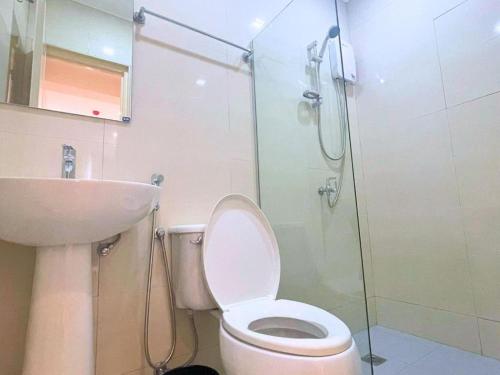 a bathroom with a toilet and a sink and a shower at Almond Suites by Hiverooms in Cebu City