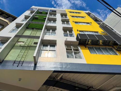 a tall building with yellow and white at Almond Suites by Hiverooms in Cebu City