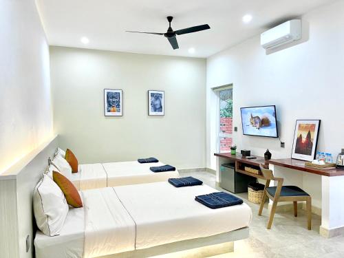 a bedroom with two beds and a desk in it at SKY VILLA - BKK Phnom Penh - Rooms & Apartments - FREE LAUNDRY in Phnom Penh