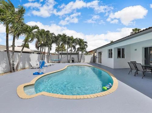 a swimming pool on a patio with palm trees at Miami Oasis With Private Pool in Richmond West
