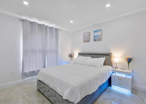a white bedroom with a large bed and a window at Miami Oasis With Private Pool in Richmond West