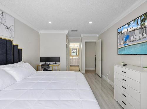 a bedroom with a large white bed and a tv at Miami Oasis With Private Pool in Richmond West