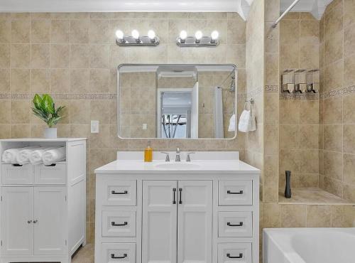 a bathroom with a white sink and a mirror at Miami Oasis With Private Pool in Richmond West