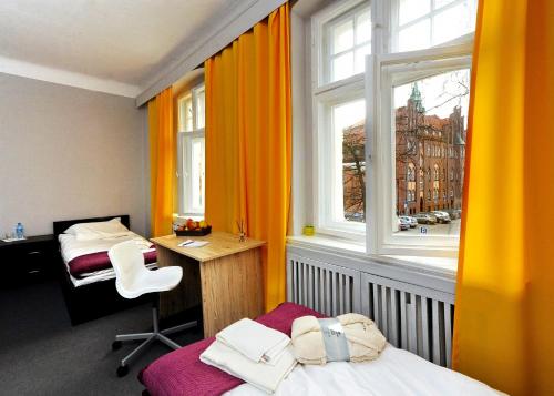 弗热希尼亚Hostel Centrum的有两张床、一张书桌和一扇窗户的房间