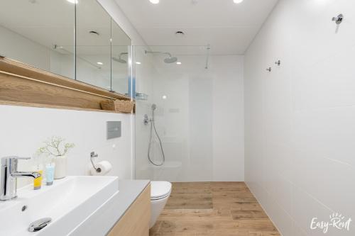 a white bathroom with a sink and a toilet at Prestige Pinea 610 - basen, sauna, jacuzzi w cenie pobytu - Easy - Rent Apartments in Pobierowo
