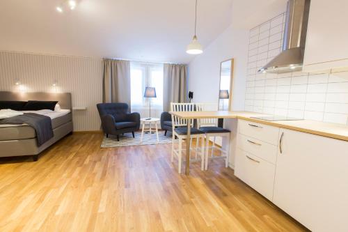 a kitchen and living room with a bed and a table at Simloc Hotel Drottninggatan in Arjeplog