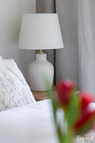 a white lamp sitting on a table next to a bed at Prestige Pinea 610 - basen, sauna, jacuzzi w cenie pobytu - Easy - Rent Apartments in Pobierowo