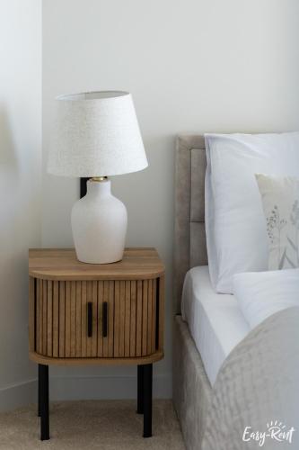 a lamp on a night stand next to a bed at Prestige Pinea 610 - basen, sauna, jacuzzi w cenie pobytu - Easy - Rent Apartments in Pobierowo