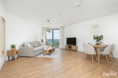a living room with a couch and a table at Prestige Pinea 610 - basen, sauna, jacuzzi w cenie pobytu - Easy - Rent Apartments in Pobierowo