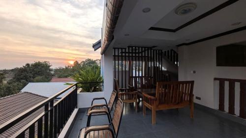 a balcony with chairs and a table on a building at VILLA Siem Reap - eco & local in Siem Reap