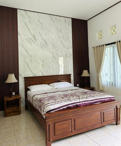 a bedroom with a large bed and two night stands at Tregge Surf Camp Uluwatu in Uluwatu