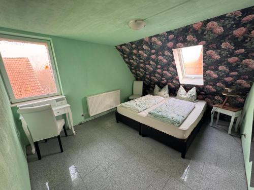 a bedroom with a bed and a wall with flowers at Farm Privatzimmer Gina Free WiFi in Hausbreitenbach