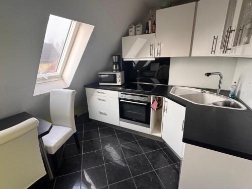 a small kitchen with a sink and a microwave at Farm Privatzimmer Gina Free WiFi in Hausbreitenbach
