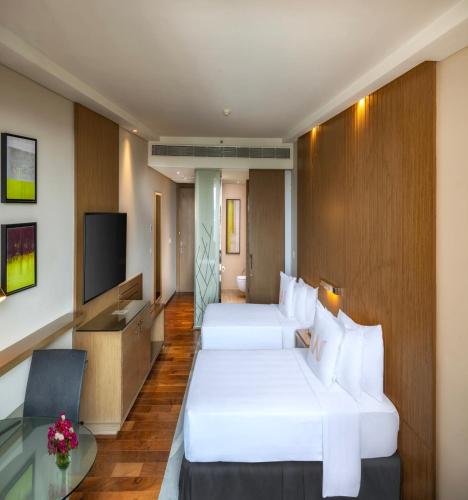 a hotel room with two beds and a television at Welcomhotel by ITC Hotels, Richmond Road, Bengaluru in Bengaluru