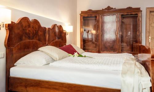 a bed with a wooden headboard in a room at Urban Stay Salzburg City in Salzburg