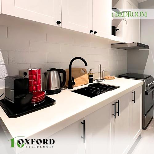 a kitchen with white cabinets and a stove top oven at 10 Oxford Residences in Quezon City