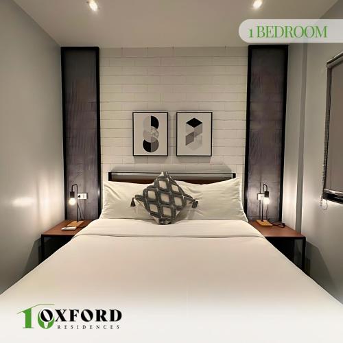 a bedroom with a large white bed with two lamps at 10 Oxford Residences in Quezon City