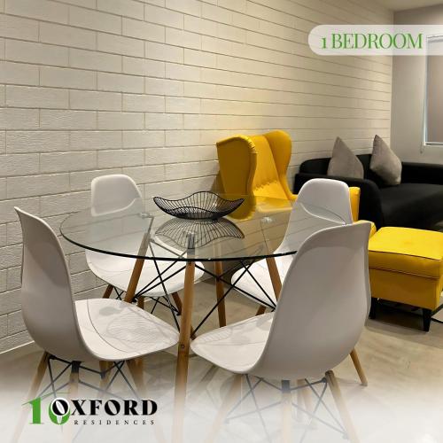 a dining room with a glass table and chairs at 10 Oxford Residences in Quezon City