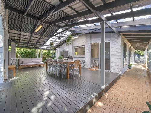 a patio with a table and chairs on a deck at Maroochy 4 Bedroom Family Beachhouse in Maroochydore