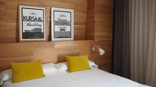 a hotel room with a bed with two yellow pillows at Zenit San Sebastián in Donostia-San Sebastián