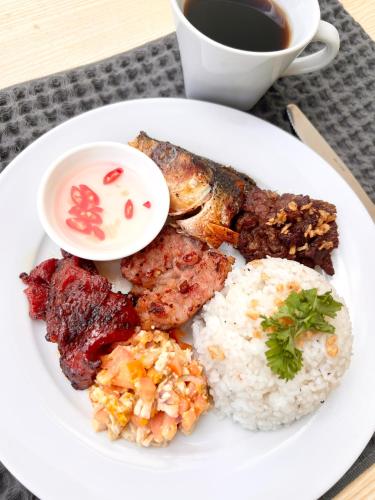 a plate of food with rice and meat and a cup of coffee at La Palme in El Nido