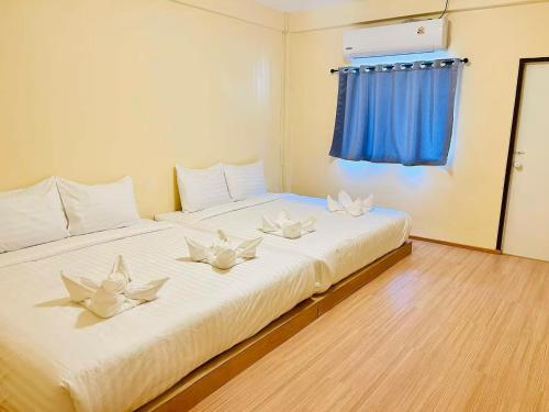 a large white bed with white flowers on it at Lamoon China Town in Hat Yai